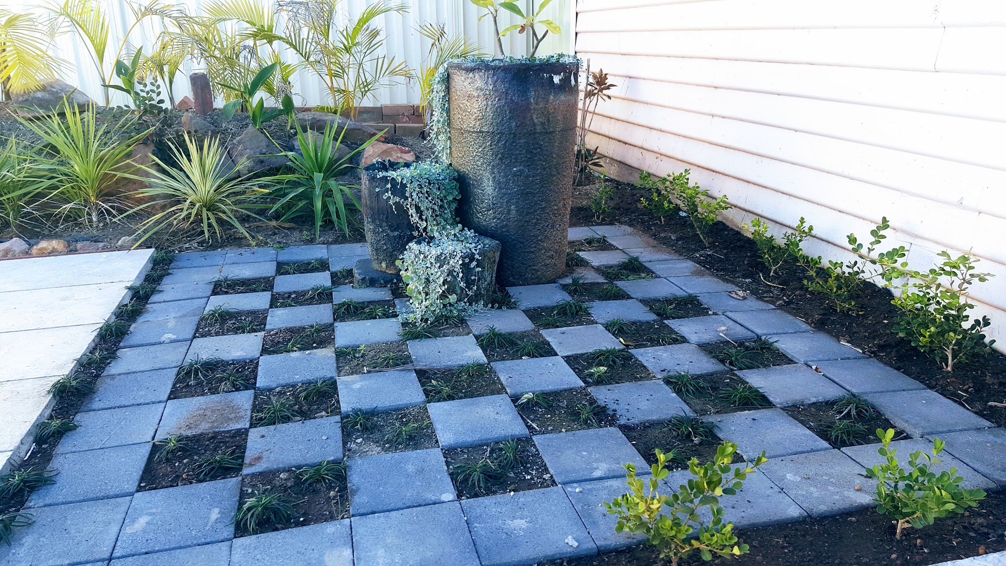 A charcoal paver and mondo grass courtyard feature laid in a Blacktown backyard.